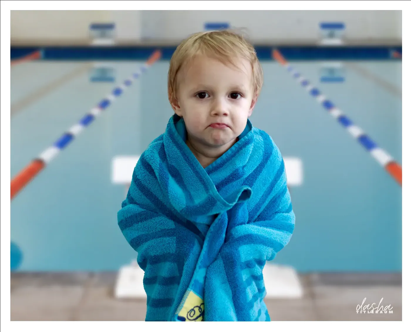 Autumn Poolside Portrait, Poolside portrait of a child wrapped in a blue towel, caught mid-thought.
